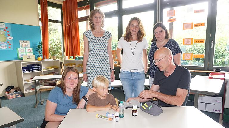 Simon Kirchner und sein Klassenlehrer Georg Schäfer kontrollieren, ob der Inhalt seiner Notfall-Allergie-Tasche auch vollständig ist. Mit im Bild von links: Maria Seiler (Mittagsbetreuung), Rektorin Jutta Spee, Melanie Kirchner und Bürgermeisterin Sonja Reubelt. Simon Kirchner und sein Klassenlehrer Georg Schäfer kontrollieren, ob der Inhalt seiner Notfall-Allergie-Tasche auch vollständig ist. Mit im Bild von links: Maria Seiler (Mittagsbetreuung), Rektorin Jutta Spee, Melanie Kirchner und Bürgermeisterin Sonja Reubelt.