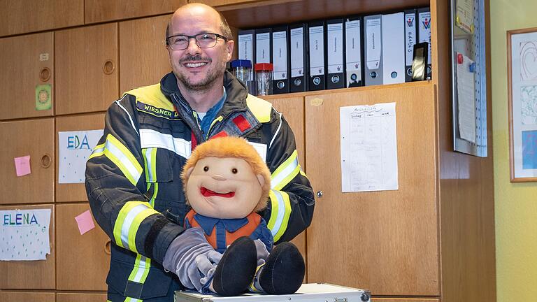 Dirk Wiesner mit der Handpuppe 'Fix': Die Puppe soll ein Eisbrecher für die Kinder sein und den Feuerwehrmann in Einsatzkleidung weniger bedrohlich wirken lassen. Dirk Wiesner mit der Handpuppe 'Fix': Die Puppe soll ein Eisbrecher für die Kinder sein und den Feuerwehrmann in Einsatzkleidung weniger bedrohlich wirken lassen.