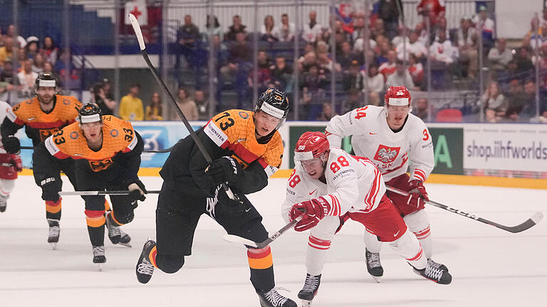 Deutschland - Polen.jpeg       -  Deutschlands Lukas Reichel (links) in Aktion gegen Polens Alan Lyszczarczyk. Am Samstag holte die deutsche Eishockey-Nationalmannschaft den Sieg gegen Polen und hat das  Viertelfinale der WM erreicht.