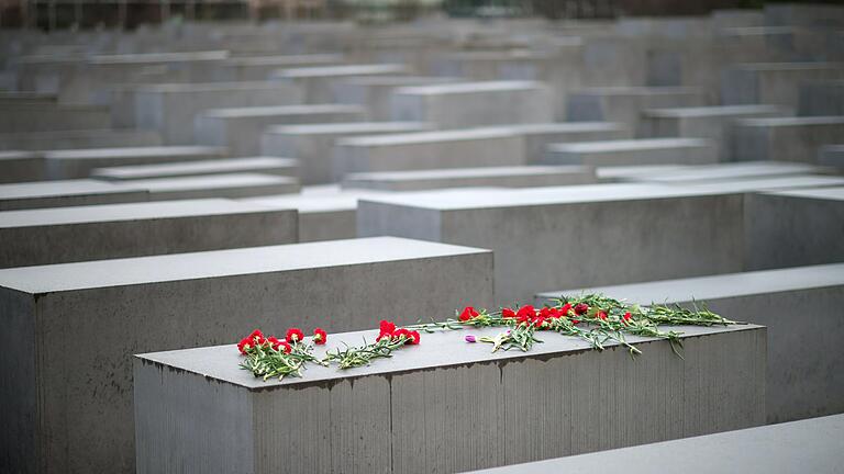 Blumen liegen auf einem Stein des Holocaust-Mahnmals in Berlin.