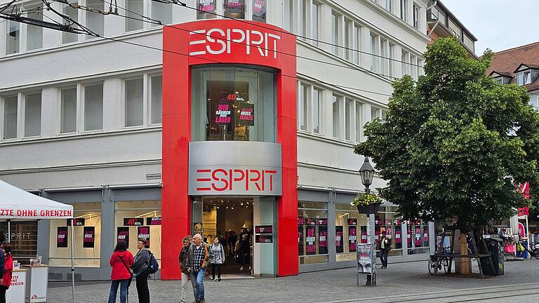 Große Plakate an leeren Schaufenstern weisen auf den Lagerräumungsverkauf bei Esprit am Würzburger Dominikanerplatz hin.