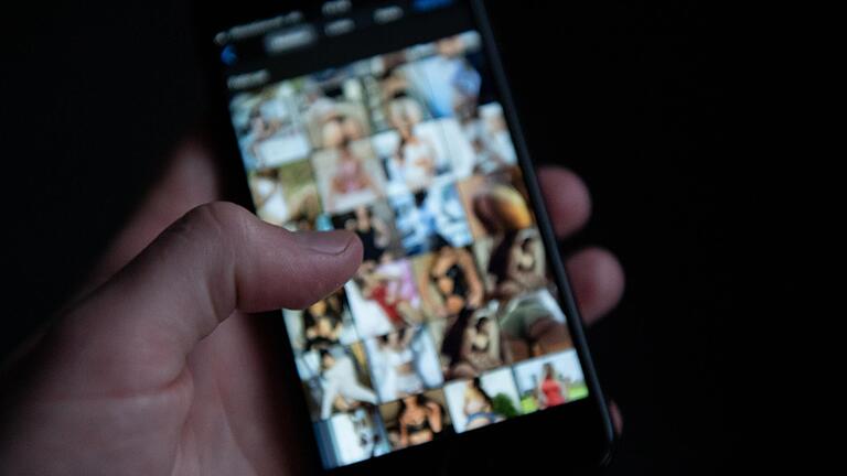 Symbolfoto: Ein Mann schaut sich auf einem Smartphone pornografische Bilder an. Symbolfoto: Ein Mann schaut sich auf einem Smartphone pornografische Bilder an.
