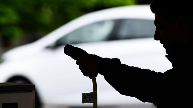 E-Ladekabel in Hand von Autofahrer.jpeg       -  Versicherungen für E-Autos sind aktuell genauso teuer wie die für Verbrenner – dabei sind die Reparaturkosten höher.