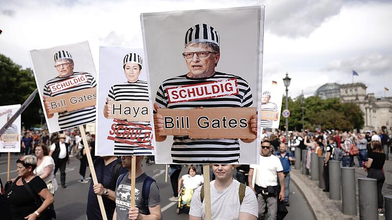 Teilnehmer einer Demonstration gegen die Corona-Maßnahmen halten Schilder mit Fotos von Politikern, Journalisten und Wissenschaftlern jeweils mit Namen und &quot;Schuldig&quot;, rechts Microsoft Gründer Bill Gates.