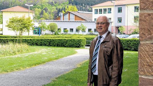 Abschied nach 24 Jahren: Mit sich im Reinen scheidet Franz Schüßler, der dienstälteste Bürgermeister im Raum Gemünden, aus dem Amt. Ein Lieblingsort Schüßlers ist der Park am Wasserschloss mit dem Gesindehof, von wo aus er einen Blick auf die generalsanierte Sinngrundschule (im Hintergrund) hat, eines der großen Projekte seiner Amtszeit.