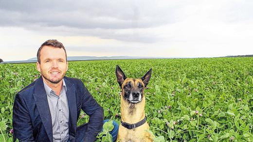 Alles im Blick: Johannes Scharnagel betrachtet die Erbsen und Wicken, die er auf einem der Felder gepflanzt hat. Vor fünf Jahren hat der Nebenerwerbslandwirt, der eine zweite Ausbildung zum Steuerberater gemacht hat, auf Bio umgestellt. Hündin Ela begleitet ihn auf jedem Schritt.