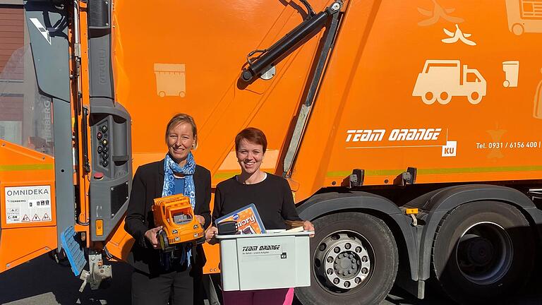 Eva von Vietinghoff-Scheel, Vorständin des Kommunalunternehmens des Landkreises Würzburg, zusammen mit Maria Bethge, zuständig für Nachhaltigkeit und Kommunikation beim team orange, mit dem pädagogischen Material zum Ausleihen für Kindergärten und Grundschulen des Landkreises Würzburg.