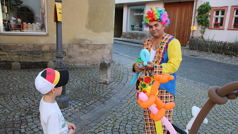 Stadtfest Münnerstadt 2024 - Einer der beliebtesten Männer beim Stadtfest: der Luftballon-Clown. Hier formt er für den Jungen ein Schwert. Stadtfest Münnerstadt 2024 - Einer der beliebtesten Männer beim Stadtfest: der Luftballon-Clown. Hier formt er für den Jungen ein Schwert.
