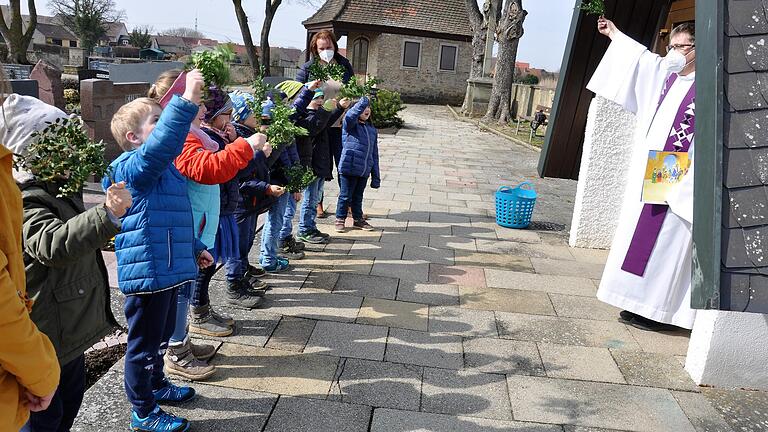 In Erinnerung an den Einzug Jesu nach Jerusalem winken die Vorschüler, zusammen mit Pfarrer Thomas Amrehn mit ihren Buchsbaumzweigen, die Inge Sternecker mitgebracht und an die Kinder verteilt hatte.