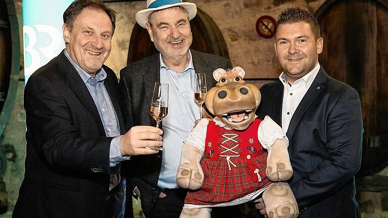 Freuen sich auf 30 Jahre Fernsehprunksitzung &bdquo;Fastnacht in Franken&ldquo; (von links): BR-Redaktionsleiter Norbert Küber, Bernhard Schlereth, Präsident des Fastnacht-Verbands Franken, Nilpferddame Amanda und der Würzburger Bauchredner Sebastian Reich.