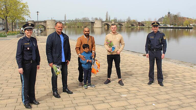 Termin am Mainkai, wo Vater und Sohn ins eiskalte Wasser gefallen waren: Der Dienststellenleiter der Kitzinger Polizeiinspektion Jochen Dietrich (rechts) und seine Stellvertreterin Simone Schatz (links) mit (weiter von links) Jochen Burger, Venkata Sadu mit Sohn Mahatru und Niclas Burger.