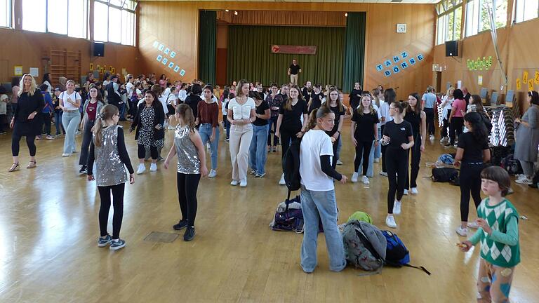 Über 140 Schülerinnen, Schüler, Lehrkräfte und Gäste folgten beim abschließenden Line Dance den Anweisungen von Lorenz Schmitt von der Tanzschule Pelzer (im Hintergrund auf der Bühne).