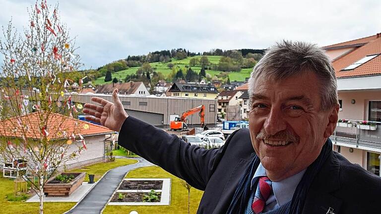 Das neue Zentrum: Frammersbachs Bürgermeister Peter Franz steht auf dem Balkon des im Oktober mitten im Ortskern eröffneten Seniorenheimes. Im Hintergrund der von der Gemeinde errichtete große Lebensmittelmarkt, der im Juni eröffnet.