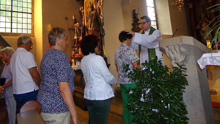 Neupriester Tommy Reißig spendet den selten gewordenen Primizsegen, für den zahlreiche Gläubige zum Gottesdienst nach Eichelsee gekommen sind.