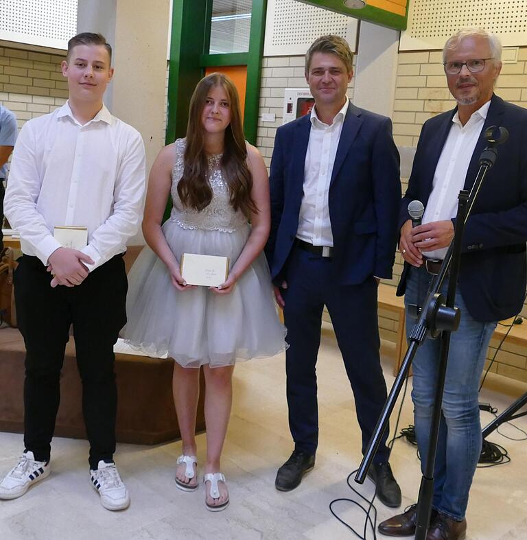 Rektor Achim Libischer (rechts) und Bürgermeister Michael Kraus ehrten Justin Klein und Lilly Löhler für hervorragende Leistungen.