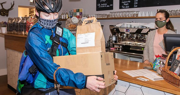 Lieferdienste im Trend: Die Radbotin Helen Stöckel nimmt Päckchen in einem Café in der Würzburger Innenstadt entgegen, um sie zu den Kunden zu bringen. Lieferdienste im Trend: Die Radbotin Helen Stöckel nimmt Päckchen in einem Café in der Würzburger Innenstadt entgegen, um sie zu den Kunden zu bringen.
