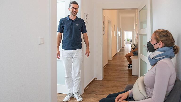 Dr. Matthias Hock holt eine Patientin vom Warteplatz im Gang zur Behandlung in seinem Sprechzimmer ab. Dr. Matthias Hock holt eine Patientin vom Warteplatz im Gang zur Behandlung in seinem Sprechzimmer ab.