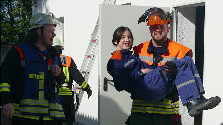 Strahlende Gesichter: Ein eingeschlossenes Mädchen wird bei der Großübung der Feuerwehr in Hohenfeld sicher geborgen.