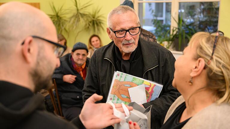 Ein Dankeschön für den prominenten Besucher: Konstantin Wecker hat in der Wärmestube nicht nur von den Veranstaltern, sondern auch von einem Gast Geschenke bekommen.