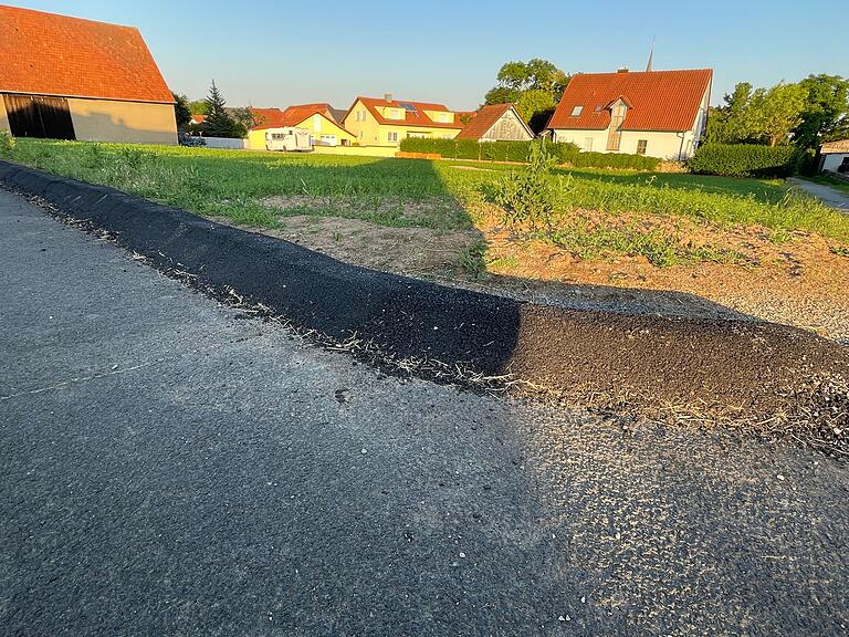 Mit einer geteerten Barrikade will man das Wasser von dieser Fläche fernhalten und gezielt in den Kanal lenken.