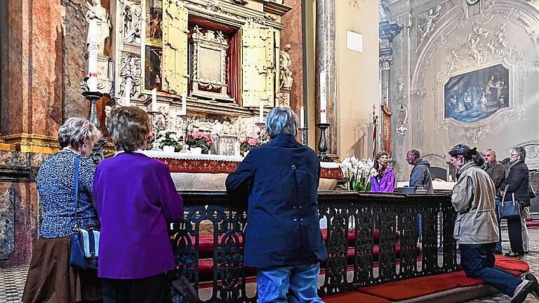 Eröffnung der Wallfahrt in Walldürn       -  Der Schrein ist geöffnet: Gläubige knien in Walldürn in der Wallfahrtsbasilika vor dem Heilig-Blut-Altar. Bis zu 50 000 Pilger aus ganz Deutschland werden in den kommenden vier Wochen in Walldürn erwartet.