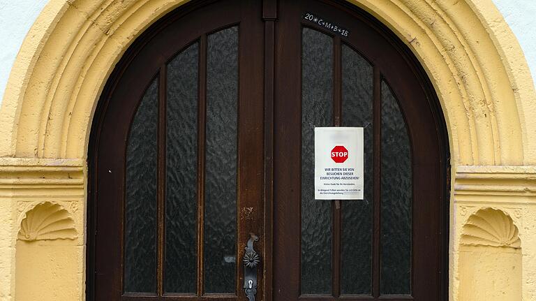 An einer Zugangstür zu dem Seniorenheim ist ein Schild angebracht, das von Besuchen dieser Einrichtung abrät.&nbsp;