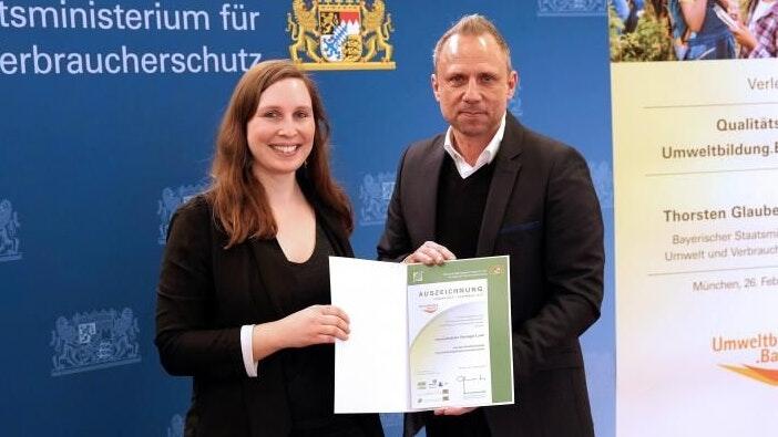 Umweltminister Thorsten Glauber überreichte Ronja Rohlik, Leitung der Umweltstation Kitzinger Land, das Qualitätssiegel.