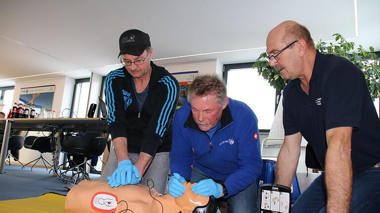 Unter Anleitung von Rettungsassistent Uve Bartz (rechts) üben Frank Keidel und Ulf Wagner an einer Puppe die Herz-Lungen-Wiederbelebung: 30 Mal drücken, dann zwei Atemstöße. Foto: Ralf Ruppert       -  Unter Anleitung von Rettungsassistent Uve Bartz (rechts) üben Frank Keidel und Ulf Wagner an einer Puppe die Herz-Lungen-Wiederbelebung: 30 Mal drücken, dann zwei Atemstöße. Foto: Ralf Ruppert