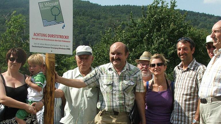 Damit ist das Ende der Brunnengalerie Hofstetten wohl endgültig besiegelt: In seiner jüngsten Sitzung beschloss des Verwaltungsrat des Zweckverbands Fernwasserversorgung (FWM) den vom Landesamt für Umwelt und dem Wasserwirtschaftsamt Aschaffenburg geforderten Rückbau der sechs Brunnen. Das Thema hat das Zeug zum Eintrag ins Schwarzbuch des Bundes der Steuerzahler. FWM-Werkleiter Alexander Schraml spricht von einem „Schildbürgerstreich“ zu Lasten der Steuer- und Gebührenzahler. Ein Sieg ist der beschlossene Rückbau hingegen für die Hofstettener Bürgerinitiative Wasser, die sich seit mehr als 20 Jahren gegen den Brunnenbau und die Trinkwassergewinnung in ihrer Gemarkung zur Wehr gesetzt hat. Bereits 1965 waren vom Landesamt für Wasserwirtschaft erste Erkundungen vorgenommen worden. In den Jahren 1980 und 1981 wurden die sechs Brunnen schließlich gebohrt. Die Gesamtkosten von rund 15 Millionen Mark wurden fast vollständig durch staatliche Fördergelder gedeckt, teilt die stellvertretende FWM-Werkleiterin Eva von Vietinghoff-Scheel auf Anfrage mit. In den Regelbetrieb gingen die Brunnen nie, wohl auch, weil sich bereits Mitte der 80er Jahre Widerstand gegen die erforderliche Ausweisung von Wasserschutzgebieten formiert hatte. Zum Desaster wurde schließlich ein Pumpversuch im Jahr 2000, bei dem durch die Wasserentnahme der Grundwasserspiegel erheblich sank und sogar eine vorhandene Quelle versiegte. Zusätzliche Rückdeckung erhielten die Brunnengegner vom Landesamt für Umwelt und dem Wasserwirtschaftsamt in Aschaffenburg. Die Behörden forderten, dass die nicht genutzten Brunnen rückgebaut und verfüllt werden, weil von durch sie langfristig Verunreinigungen ins Grundwasser eindringen könnte. Im Herbst 2015 wurde der FWM aufgefordert ein Rückbaukonzept vorzulegen – zunächst ohne Ergebnis.
Das Thema kam zurück auf die Tagesordnung, als das Kommunalunternehmen des Landkreises Würzburg (KU) im Oktober 2016 die Geschäfte des Zweckverbands übernahm. Der neue Werkleiter und KU-Vorstand Alexander Schraml trat für eine neuerliche Überprüfung der Brunnen ein, mit dem Ziel, sie doch noch für die Trinkwassergewinnung zu nutzen, wenn auch in geringerem Umfang als ursprünglich geplant. Schraml argumentierte, dass es im unterfränkischen Wassermangelgebiet vernünftig sei, die Brunnen vor dem Hintergrund des Klimawandels zumindest als Reserve vorzuhalten. Doch auch nach mehreren Gesprächen wollten sich das Landesamt für Umwelt, das Wasserwirtschaftsamt und das Landratsamt in Karlstadt den Argumenten des Zweckverbands nicht anschließen. Jetzt zog der FWM auch offiziell den Schlussstrich und beschloss den Rückbau. Bis es tatsächlich soweit kommt, werden allerdings noch ein paar Jahre vergehen. Ab 2020 sollen die Kosten in den Wirtschaftsplan aufgenommen werden, so der Verbandsvorsitzende und Würzburger Landrat Eberhard Nuß. 2022 soll der Rückbau tatsächlich vollzogen werden, nachdem der Zweckverband in den kommenden Jahren bereits eine Reihe von Sanierungen in seinem Leitungsnetz plant, die als dringlicher angesehen werden. Der Zeitplan sei mit dem Wasserwirtschaftsamt abgestimmt, nachdem durch die Brunnenanlage keine Gefährdung für das Grundwasser ausgehe. Die Zeit bis dahin will Werkleiter Alexander Schraml für die Suche nach einem günstigeren Rückbaukonzept nutzen. Bisher gehen Schätzungen von 400 000 bis 500 000 Euro aus, die letztlich auf die Gebühren umgelegt werden müssen. Derzeit zahlen die angeschlossenen Gemeinden 1,05 Euro pro Kubikmeter Trinkwasser. Verbandsvorsitzender Nuß kann in der Rückschau nur den Kopf schütteln. „Da ist wahnsinnig viel Geld vergraben worden für nichts und wieder nichts, aber die Rechtslage ist eindeutig“, so Nuß in der Sitzung des Verwaltungsrats. Deutlicher drückt sich Werkleiter Schraml aus: „Es ist ein Schildbürgerstreich, dass damals mit wehenden Fahnen und staatlicher Hilfe Geld in den Sand gesetzt wurde und es die Gebührenzahler heute ausbaden müssen.“ Nachdem die Brunnen vor allem auf Betreiben des Landesamts für Wasserwirtschaft gebaut wurden, sieht Schraml deshalb auch beim Rückbau den Staat in der Pflicht. Damit ist das Ende der Brunnengalerie Hofstetten wohl endgültig besiegelt: In seiner jüngsten Sitzung beschloss des Verwaltungsrat des Zweckverbands Fernwasserversorgung (FWM) den vom Landesamt für Umwelt und dem Wasserwirtschaftsamt Aschaffenburg geforderten Rückbau der sechs Brunnen. Das Thema hat das Zeug zum Eintrag ins Schwarzbuch des Bundes der Steuerzahler. FWM-Werkleiter Alexander Schraml spricht von einem „Schildbürgerstreich“ zu Lasten der Steuer- und Gebührenzahler. Ein Sieg ist der beschlossene Rückbau hingegen für die Hofstettener Bürgerinitiative Wasser, die sich seit mehr als 20 Jahren gegen den Brunnenbau und die Trinkwassergewinnung in ihrer Gemarkung zur Wehr gesetzt hat. Bereits 1965 waren vom Landesamt für Wasserwirtschaft erste Erkundungen vorgenommen worden. In den Jahren 1980 und 1981 wurden die sechs Brunnen schließlich gebohrt. Die Gesamtkosten von rund 15 Millionen Mark wurden fast vollständig durch staatliche Fördergelder gedeckt, teilt die stellvertretende FWM-Werkleiterin Eva von Vietinghoff-Scheel auf Anfrage mit. In den Regelbetrieb gingen die Brunnen nie, wohl auch, weil sich bereits Mitte der 80er Jahre Widerstand gegen die erforderliche Ausweisung von Wasserschutzgebieten formiert hatte. Zum Desaster wurde schließlich ein Pumpversuch im Jahr 2000, bei dem durch die Wasserentnahme der Grundwasserspiegel erheblich sank und sogar eine vorhandene Quelle versiegte. Zusätzliche Rückdeckung erhielten die Brunnengegner vom Landesamt für Umwelt und dem Wasserwirtschaftsamt in Aschaffenburg. Die Behörden forderten, dass die nicht genutzten Brunnen rückgebaut und verfüllt werden, weil von durch sie langfristig Verunreinigungen ins Grundwasser eindringen könnte. Im Herbst 2015 wurde der FWM aufgefordert ein Rückbaukonzept vorzulegen – zunächst ohne Ergebnis.
Das Thema kam zurück auf die Tagesordnung, als das Kommunalunternehmen des Landkreises Würzburg (KU) im Oktober 2016 die Geschäfte des Zweckverbands übernahm. Der neue Werkleiter und KU-Vorstand Alexander Schraml trat für eine neuerliche Überprüfung der Brunnen ein, mit dem Ziel, sie doch noch für die Trinkwassergewinnung zu nutzen, wenn auch in geringerem Umfang als ursprünglich geplant. Schraml argumentierte, dass es im unterfränkischen Wassermangelgebiet vernünftig sei, die Brunnen vor dem Hintergrund des Klimawandels zumindest als Reserve vorzuhalten. Doch auch nach mehreren Gesprächen wollten sich das Landesamt für Umwelt, das Wasserwirtschaftsamt und das Landratsamt in Karlstadt den Argumenten des Zweckverbands nicht anschließen. Jetzt zog der FWM auch offiziell den Schlussstrich und beschloss den Rückbau. Bis es tatsächlich soweit kommt, werden allerdings noch ein paar Jahre vergehen. Ab 2020 sollen die Kosten in den Wirtschaftsplan aufgenommen werden, so der Verbandsvorsitzende und Würzburger Landrat Eberhard Nuß. 2022 soll der Rückbau tatsächlich vollzogen werden, nachdem der Zweckverband in den kommenden Jahren bereits eine Reihe von Sanierungen in seinem Leitungsnetz plant, die als dringlicher angesehen werden. Der Zeitplan sei mit dem Wasserwirtschaftsamt abgestimmt, nachdem durch die Brunnenanlage keine Gefährdung für das Grundwasser ausgehe. Die Zeit bis dahin will Werkleiter Alexander Schraml für die Suche nach einem günstigeren Rückbaukonzept nutzen. Bisher gehen Schätzungen von 400 000 bis 500 000 Euro aus, die letztlich auf die Gebühren umgelegt werden müssen. Derzeit zahlen die angeschlossenen Gemeinden 1,05 Euro pro Kubikmeter Trinkwasser. Verbandsvorsitzender Nuß kann in der Rückschau nur den Kopf schütteln. „Da ist wahnsinnig viel Geld vergraben worden für nichts und wieder nichts, aber die Rechtslage ist eindeutig“, so Nuß in der Sitzung des Verwaltungsrats. Deutlicher drückt sich Werkleiter Schraml aus: „Es ist ein Schildbürgerstreich, dass damals mit wehenden Fahnen und staatlicher Hilfe Geld in den Sand gesetzt wurde und es die Gebührenzahler heute ausbaden müssen.“ Nachdem die Brunnen vor allem auf Betreiben des Landesamts für Wasserwirtschaft gebaut wurden, sieht Schraml deshalb auch beim Rückbau den Staat in der Pflicht.