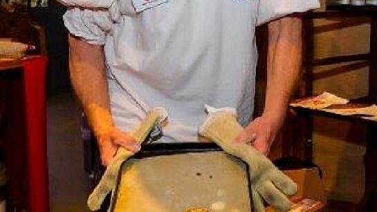 Achtung, heiß! Museumsbäcker Josef Buchner holt ein Blech mit frischen Lebkuchen aus dem Backofen.