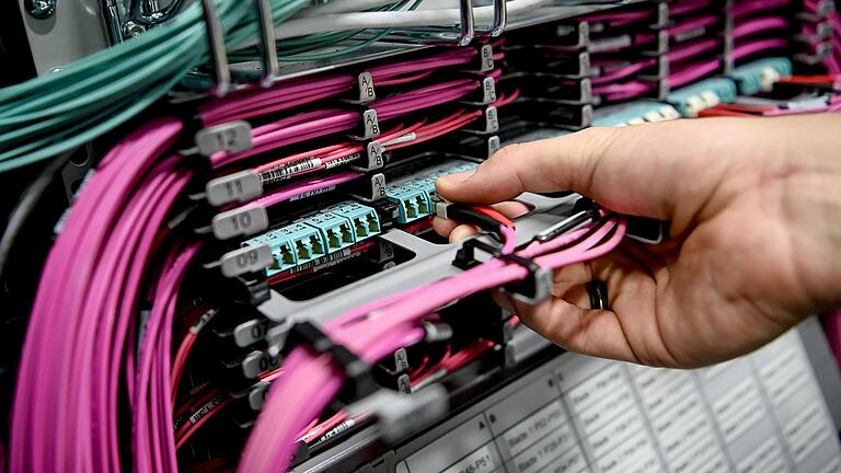 Ein Systemadministrator zieht Lichtwellenleiter aus den Massenspeichergeräten in einem Rechenzentrum. An der Uni Würzburg ist am Montag die Kühlung ausgefallen – Server fielen aus. Ein Systemadministrator zieht Lichtwellenleiter aus den Massenspeichergeräten in einem Rechenzentrum. An der Uni Würzburg ist am Montag die Kühlung ausgefallen – Server fielen aus.