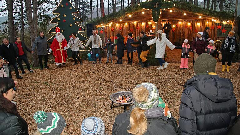 Bei der Leinacher Waldweihnacht beteiligten sich viele Gäste, darunter Landrat Thomas Eberth, an einem Tanz-Kreis als typisch ukrainischem Weihnachtsbrauch. Bei der Leinacher Waldweihnacht beteiligten sich viele Gäste, darunter Landrat Thomas Eberth, an einem Tanz-Kreis als typisch ukrainischem Weihnachtsbrauch.