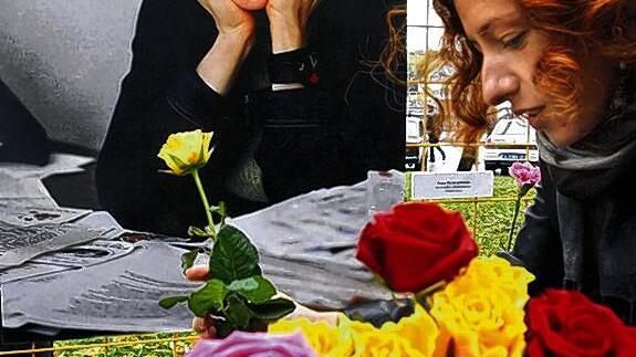 Eine Frau legt Blumen nieder vor einem Foto der ermordeten Anna Politkowskaya.