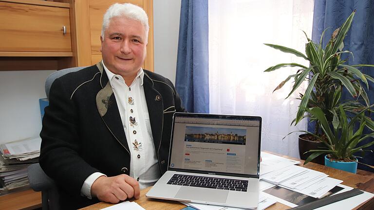 Der AfD-Abgeordnete Christian Klingen präsentiert in seinem Bürgerbüro am Marktplatz in Kitzingen seine Internetseiten auf dem Laptop.