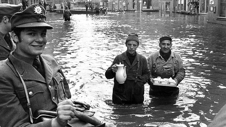 Das Hochwasser vom Februar 1970: Mit Kaffee und Kuchen durch die Fluten in der Würzburger Karmelitenstraße. Das Hochwasser vom Februar 1970: Mit Kaffee und Kuchen durch die Fluten in der Würzburger Karmelitenstraße.