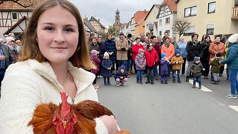 Hannah Endres traf die Dose beim „Hahnenschlag“ in Eyershausen und bekam dafür einen lebenden Hahn. Mit ihm musste sie zuvor allerdings eine Runde tanzen.