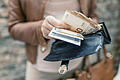 Woman holding in hands wallet with euro money. City girl is taking out money from wallet       -  Symbolbild: Geld