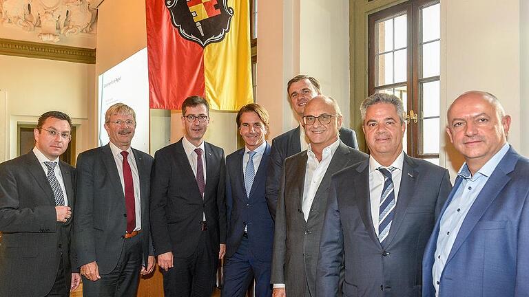 Allianz für eine Multifunktionsarena, die im Wappensaal des Würzburger Rathauses die Pläne vorstellte (von links): Stadtkämmerer Robert Scheller, Stadtbaurat Christian Baumgart, Oberbürgermeister Christian Schuchardt, Projekt-Berater Bela Anda, Thomas Oehler, Geschäftsführer der Projektgesellschaft, Armin Fichtel (Vorsitzender der Geschäftsführung von s.Oliver), Stifter Michael Reizle (BVUK.-Gruppe) sowie Gerold Bader, Eigentümer des Grundstücks, auf dem die Arena gebaut werden soll. Allianz für eine Multifunktionsarena, die im Wappensaal des Würzburger Rathauses die Pläne vorstellte (von links): Stadtkämmerer Robert Scheller, Stadtbaurat Christian Baumgart, Oberbürgermeister Christian Schuchardt, Projekt-Berater Bela Anda, Thomas Oehler, Geschäftsführer der Projektgesellschaft, Armin Fichtel (Vorsitzender der Geschäftsführung von s.Oliver), Stifter Michael Reizle (BVUK.-Gruppe) sowie Gerold Bader, Eigentümer des Grundstücks, auf dem die Arena gebaut werden soll.