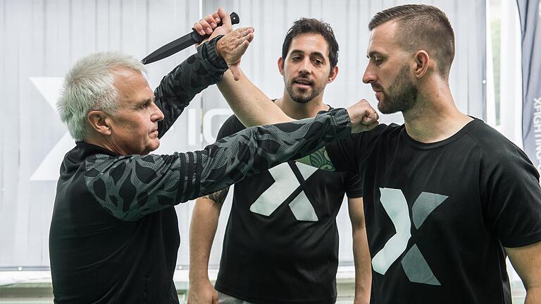 Messerhand abblocken, die Faust fährt aus. Wenn diese Reaktion geschult ist und in Sekundenbruchteilen kommt, kann dies einem potenziellen Opfer das Leben retten. Bert Bauer (rechts) und Itay Dannenberg (Mitte) unterweisen künftige Krav Maga-Instruktoren und auch völlige Anfänger, wie den Verfasser dieser Zeilen.