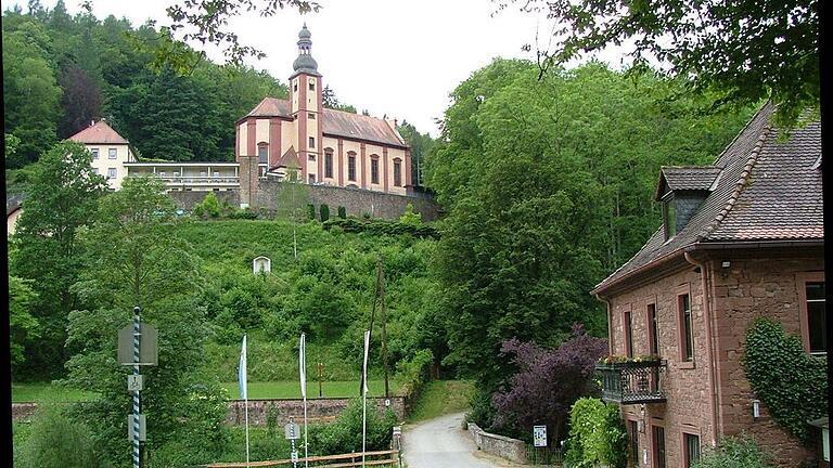 Weil er der Meinung ist, dass ihm das letzte Stück der Buchentalstraße runter zur Buchenmühle nicht gehört, sondern der Stadt Lohr, verweigert Christoph von Hutten der Energieversorgung Lohr/Karlstadt und Umgebung, in diesem Bereich ein für das Unternehmen wichtiges Mittelspannungskabel ins Erdreich zu legen. Lediglich einer Freileitung stimmt er zu, was für die „Energie“ aber wegen der Gefahr umstürzender Bäume keine befriedigende Lösung ist. Auf unserem Foto mit der über dem Tal thronenden Wallfahrtskirche Mariabuchen ist unten die Buchenmühle mit der Buchenbachbrücke und dem im Wald verschwindenden strittigen Straßenstück zu sehen. Weil er der Meinung ist, dass ihm das letzte Stück der Buchentalstraße runter zur Buchenmühle nicht gehört, sondern der Stadt Lohr, verweigert Christoph von Hutten der Energieversorgung Lohr/Karlstadt und Umgebung, in diesem Bereich ein für das Unternehmen wichtiges Mittelspannungskabel ins Erdreich zu legen. Lediglich einer Freileitung stimmt er zu, was für die „Energie“ aber wegen der Gefahr umstürzender Bäume keine befriedigende Lösung ist. Auf unserem Foto mit der über dem Tal thronenden Wallfahrtskirche Mariabuchen ist unten die Buchenmühle mit der Buchenbachbrücke und dem im Wald verschwindenden strittigen Straßenstück zu sehen.