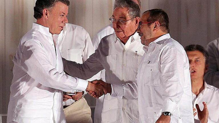Händedruck       -  Präsident Juan Manuel Santos (L) und der Kommandeur der Farc, Rodrigo Londoño, nach der Unterzeichnung des Abkommens. Foto: Mauricio Duenas Castaneda