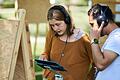 Besucherin und Besucher beim Absolvieren einer Aufgabe der Ausstellung 'Land der Kulturen'.