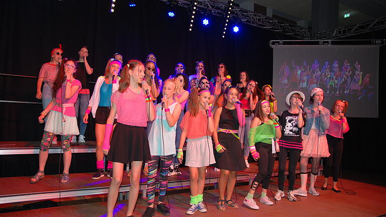 Der Chor des Balthasar-Neumann-Gymnasiums entführte in neonbunter Kleidung zurück in die 80er.