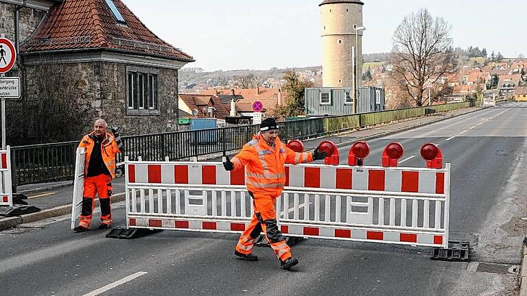 Nichts geht mehr auf der Neuen Mainbrücke - (meg) Bis in den Nachmittag hinein durfte der Verkehr am Montag noch über die Ochsenfurter Neue Mainbrücke rollen, dann war aber dicht. Um punkt 15.49 Uhr stellten Mitarbeiter einer Fachfirma die letzten Sperren auf, dann war auch für die Autofahrer, die gehofft hatten, in letzter Sekunde noch durchschlüpfen zu können, kein Weiterkommen mehr möglich. Ursprünglich hätten die Sperrarbeiten schon um 8 Uhr beginnen sollen. Doch dann verzögerte sich das Ganze bis in den Mittag. Erst nachdem die Hinweisschilder an den Zufahrten installiert waren, wurde auch die Brücke geschlossen. In den nächsten Tagen rückt die Abrissfirma an, um zunächst die Stahlleitwände abzumontieren. Anschließend sind die Gehsteige und die Fahrbahnplatte an der Reihe, bevor in der zweiten Aprilwoche der Abbau der beiden Hauptträger über dem Flussfeld beginnt. Die nächste Gelegenheit, den Main an dieser Stelle zu überqueren, wird es frühestens im Dezember 2018 geben. Nichts geht mehr auf der Neuen Mainbrücke - (meg) Bis in den Nachmittag hinein durfte der Verkehr am Montag noch über die Ochsenfurter Neue Mainbrücke rollen, dann war aber dicht. Um punkt 15.49 Uhr stellten Mitarbeiter einer Fachfirma die letzten Sperren auf, dann war auch für die Autofahrer, die gehofft hatten, in letzter Sekunde noch durchschlüpfen zu können, kein Weiterkommen mehr möglich. Ursprünglich hätten die Sperrarbeiten schon um 8 Uhr beginnen sollen. Doch dann verzögerte sich das Ganze bis in den Mittag. Erst nachdem die Hinweisschilder an den Zufahrten installiert waren, wurde auch die Brücke geschlossen. In den nächsten Tagen rückt die Abrissfirma an, um zunächst die Stahlleitwände abzumontieren. Anschließend sind die Gehsteige und die Fahrbahnplatte an der Reihe, bevor in der zweiten Aprilwoche der Abbau der beiden Hauptträger über dem Flussfeld beginnt. Die nächste Gelegenheit, den Main an dieser Stelle zu überqueren, wird es frühestens im Dezember 2018 geben.