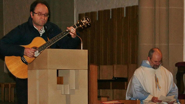 Liedermacher Franz-Josef Tremer singt in der Bad Kissinger Stadtpfarrkirche: 'Franz Reinisch, du verehrter, du bist ganz Mensch und Christ', rechts Pfarrer Armin Haas. Foto: Werner Vogel       -  Liedermacher Franz-Josef Tremer singt in der Bad Kissinger Stadtpfarrkirche: 'Franz Reinisch, du verehrter, du bist ganz Mensch und Christ', rechts Pfarrer Armin Haas. Foto: Werner Vogel