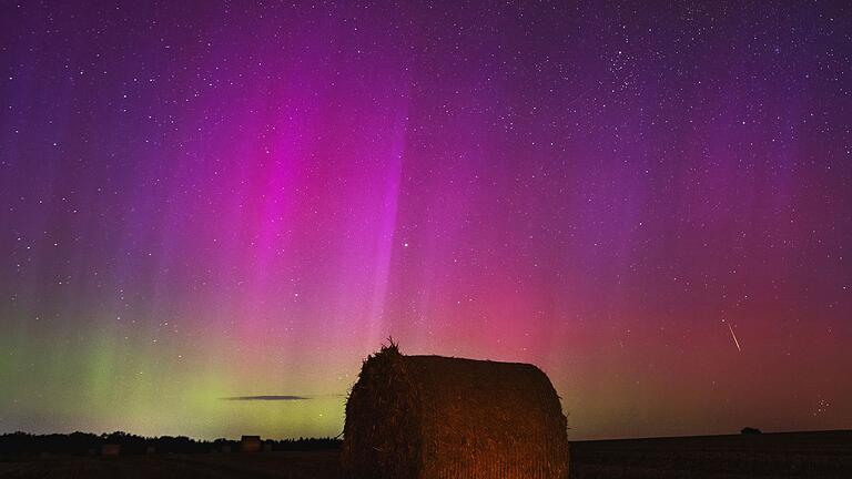 Polarlichter am Brandenburger Himmel - Nordlichter am Himmel, während eine Sternschnuppe über einem Strohballen am Himmel verglüht. Polarlichter am Brandenburger Himmel - Nordlichter am Himmel, während eine Sternschnuppe über einem Strohballen am Himmel verglüht.