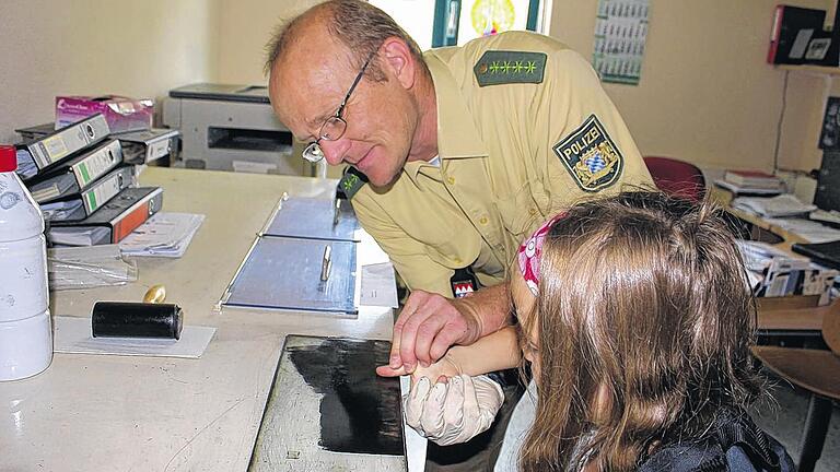 Fingerabdrücke, Rauschgifthund und 19 Kinder - (sf) Einmal Polizist sein und wie im Film Räuber und Verbrecher zur Strecke bringen: Fast jedes Kind träumt davon. Doch was steckt wirklich hinter dem Beruf eines Polizisten? Die Ferienspaß-Kinder aus Sulzheim konnten genau das herausfinden, indem sie der Polizei Gerolzhofen bei ihrem Arbeitsalltag über die Schulter schauten. Hubert Kimmel führte die 19 Kinder, die mit Bürgermeister Michael Geck angereist waren, durch den Tag. Er beeindruckte die Teilnehmer sowohl mit zahlreichen Daten, auf die ein Polizist jederzeit Zugriff hat, als auch mit dem Polizeifunk, der niemals verstummen wollte. Jedes Kind gab seinen Fingerabdruck ab und konnte sogar in einer erst kürzlich benutzten Zelle Platz nehmen und sich einsperren lassen. Das größte Erstaunen allerdings verursachte ein ausgebildeter Polizeihund, der aus den verwinkelsten Ecken Rauschgift heraus roch und blitzschnell die Fährte eines Menschen aufnehmen konnte. Nachdem nun klar war, dass der Tag eines Polizisten abwechslungsreich, aufregend und interessant zugleich ist, wurde sicher jeder einzelne Beamte zu einem noch größeren Vorbild für jedes Kind. Fingerabdrücke, Rauschgifthund und 19 Kinder - (sf) Einmal Polizist sein und wie im Film Räuber und Verbrecher zur Strecke bringen: Fast jedes Kind träumt davon. Doch was steckt wirklich hinter dem Beruf eines Polizisten? Die Ferienspaß-Kinder aus Sulzheim konnten genau das herausfinden, indem sie der Polizei Gerolzhofen bei ihrem Arbeitsalltag über die Schulter schauten. Hubert Kimmel führte die 19 Kinder, die mit Bürgermeister Michael Geck angereist waren, durch den Tag. Er beeindruckte die Teilnehmer sowohl mit zahlreichen Daten, auf die ein Polizist jederzeit Zugriff hat, als auch mit dem Polizeifunk, der niemals verstummen wollte. Jedes Kind gab seinen Fingerabdruck ab und konnte sogar in einer erst kürzlich benutzten Zelle Platz nehmen und sich einsperren lassen. Das größte Erstaunen allerdings verursachte ein ausgebildeter Polizeihund, der aus den verwinkelsten Ecken Rauschgift heraus roch und blitzschnell die Fährte eines Menschen aufnehmen konnte. Nachdem nun klar war, dass der Tag eines Polizisten abwechslungsreich, aufregend und interessant zugleich ist, wurde sicher jeder einzelne Beamte zu einem noch größeren Vorbild für jedes Kind.