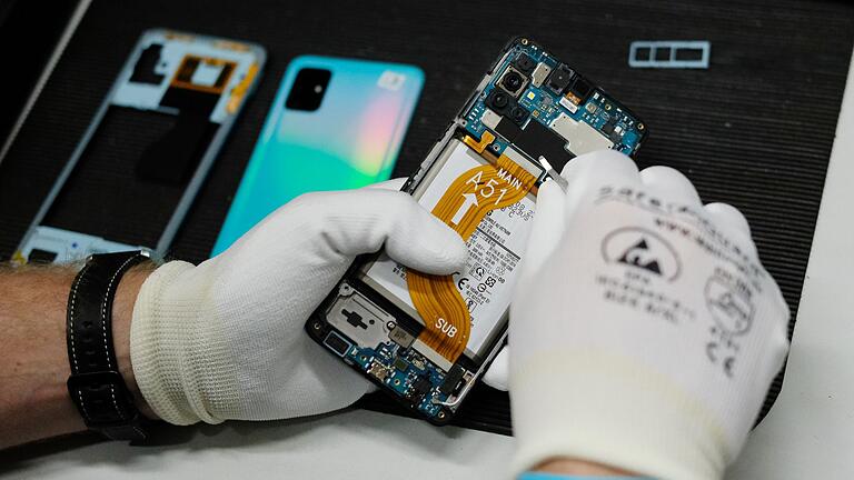 Alte Smartphones       -  In einer Werkstatt wird ein altes Smartphone wiederaufbereitet.
