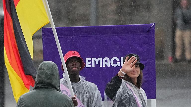 Paris 2024 - Eröffnungsfeier - Deutschlands Fahnenträger im Regen: Dennis Schröder und Anna-Maria Wagner. Paris 2024 - Eröffnungsfeier - Deutschlands Fahnenträger im Regen: Dennis Schröder und Anna-Maria Wagner.