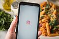 Auf einem Smartphone öffnet sich Instagram.       -  Das Smartphone auch mal zur Seite legen: Viele Menschen wollen im neuen Jahr zeitweise auf digitale Geräte verzichten.